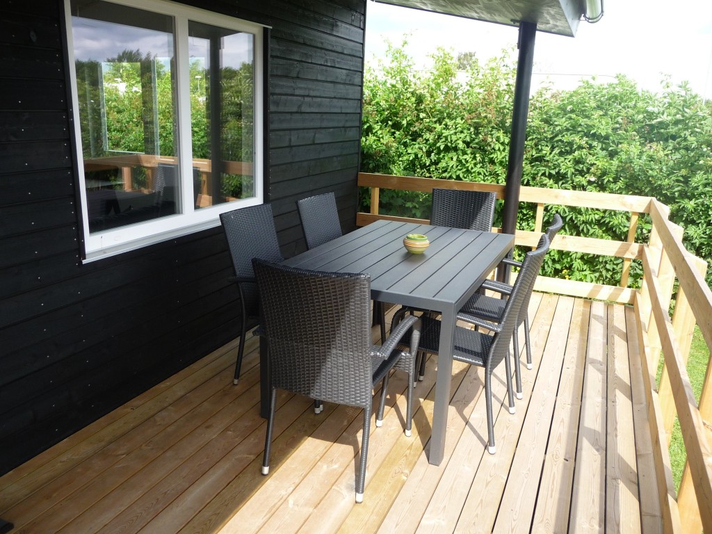 Overdækket terrasse med spisebord og stole