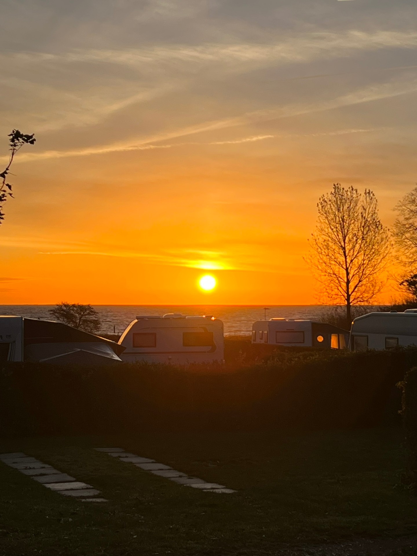 Solnedgang over campingvogne ved havet