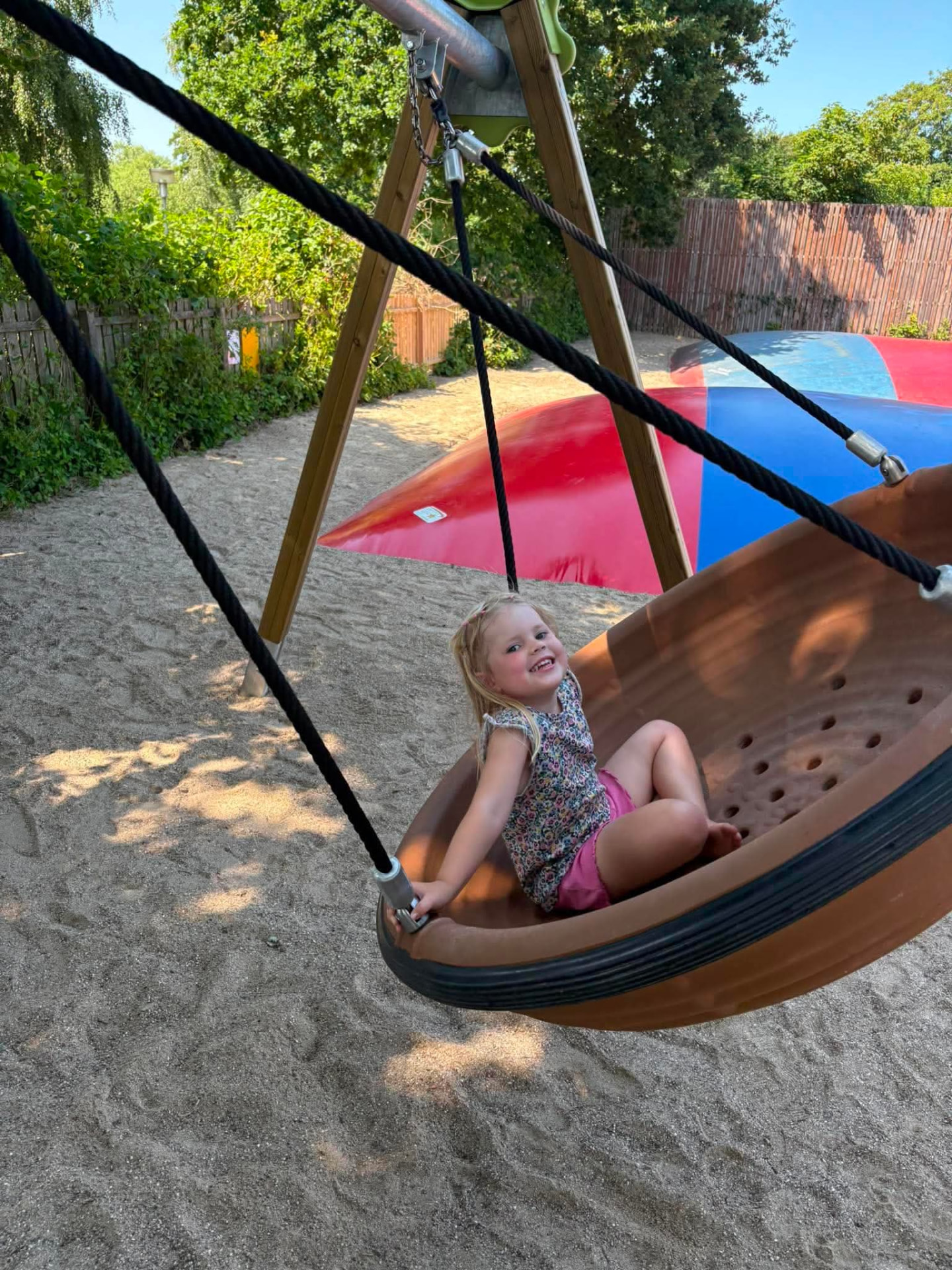 Pige i redegynge ved hoppepuderne på legepladsen