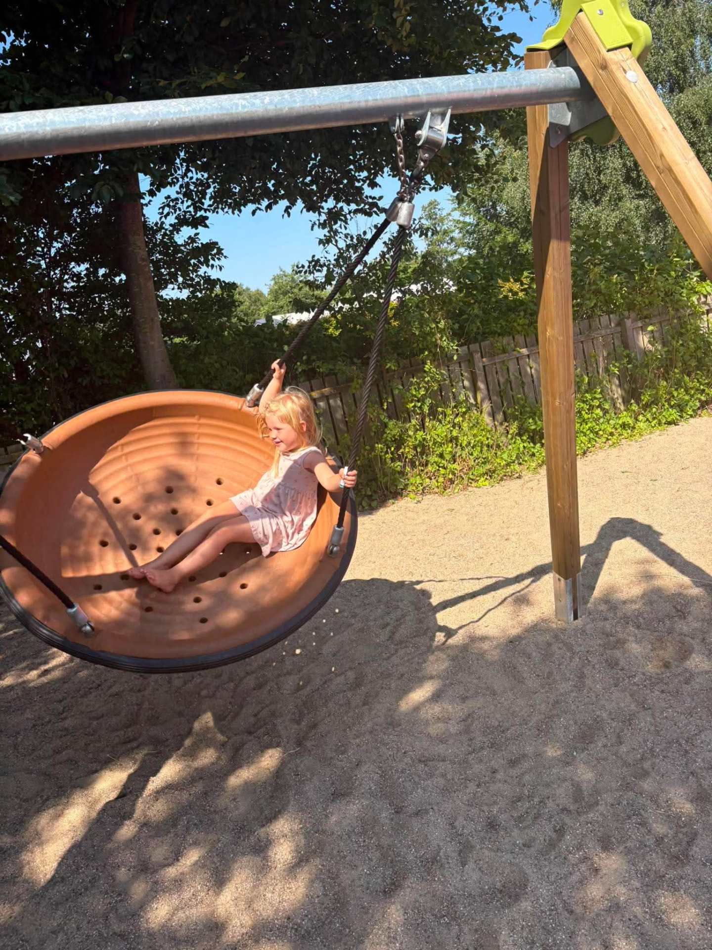 Pige gynger i redegynge en solrig sommerdag
