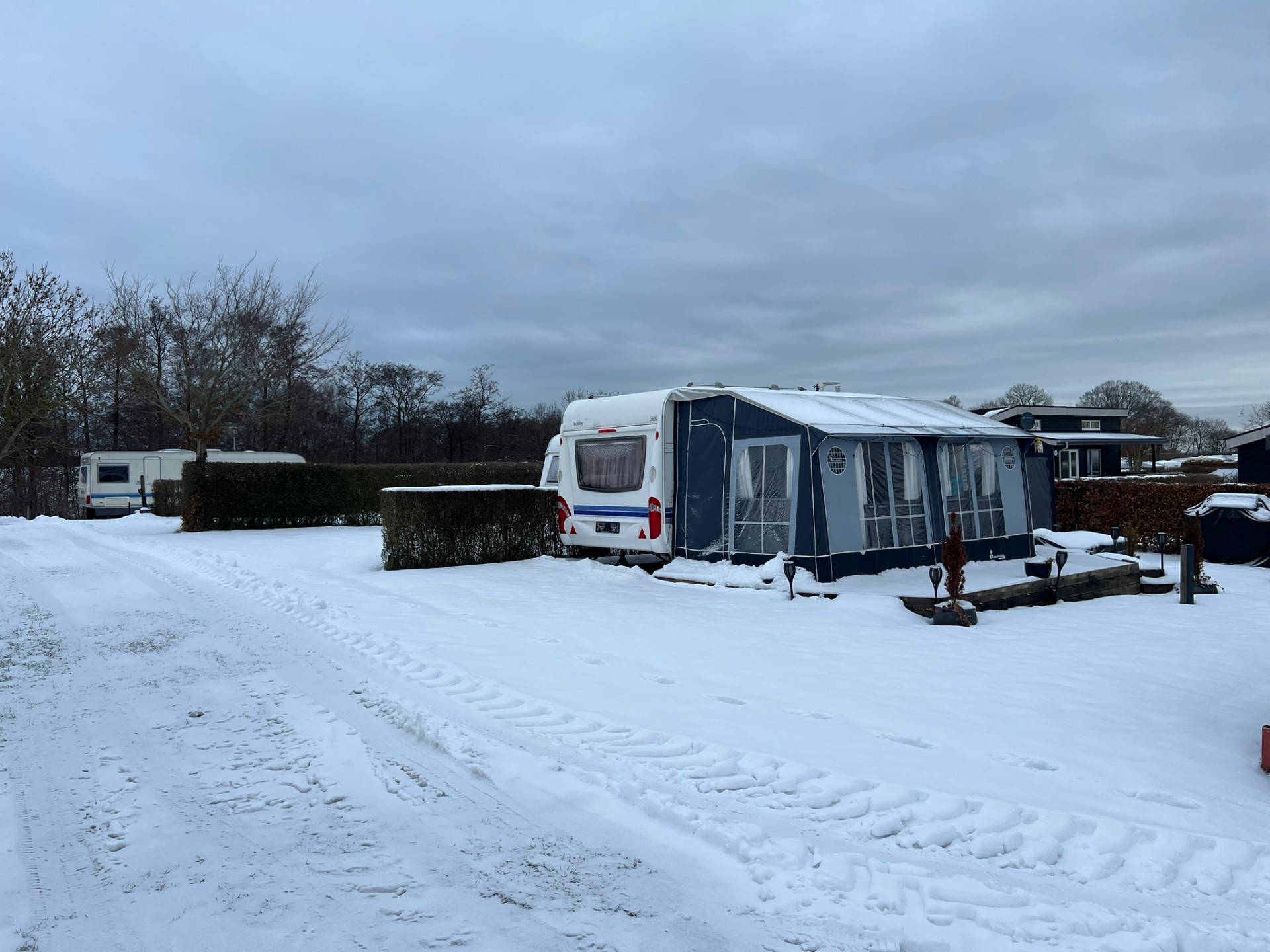 Campingvogn med fortelt i sne
