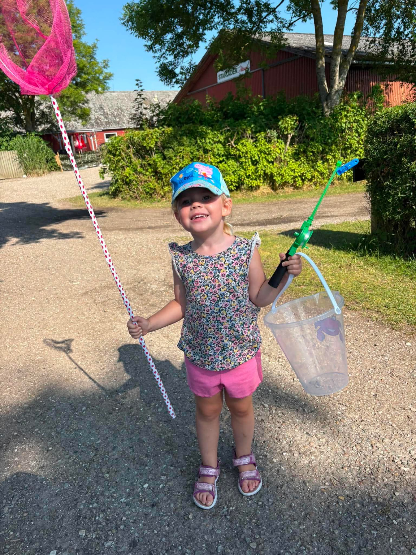 Pige med fiskenet og spand på vej til stranden