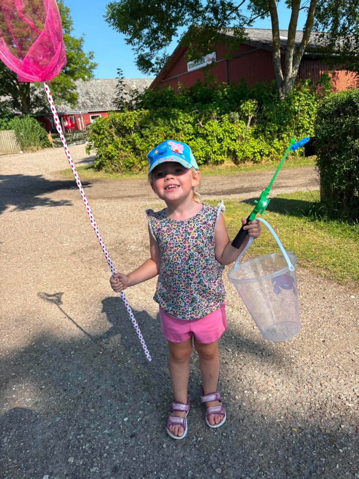 Pige med fiskenet og spand på vej til stranden