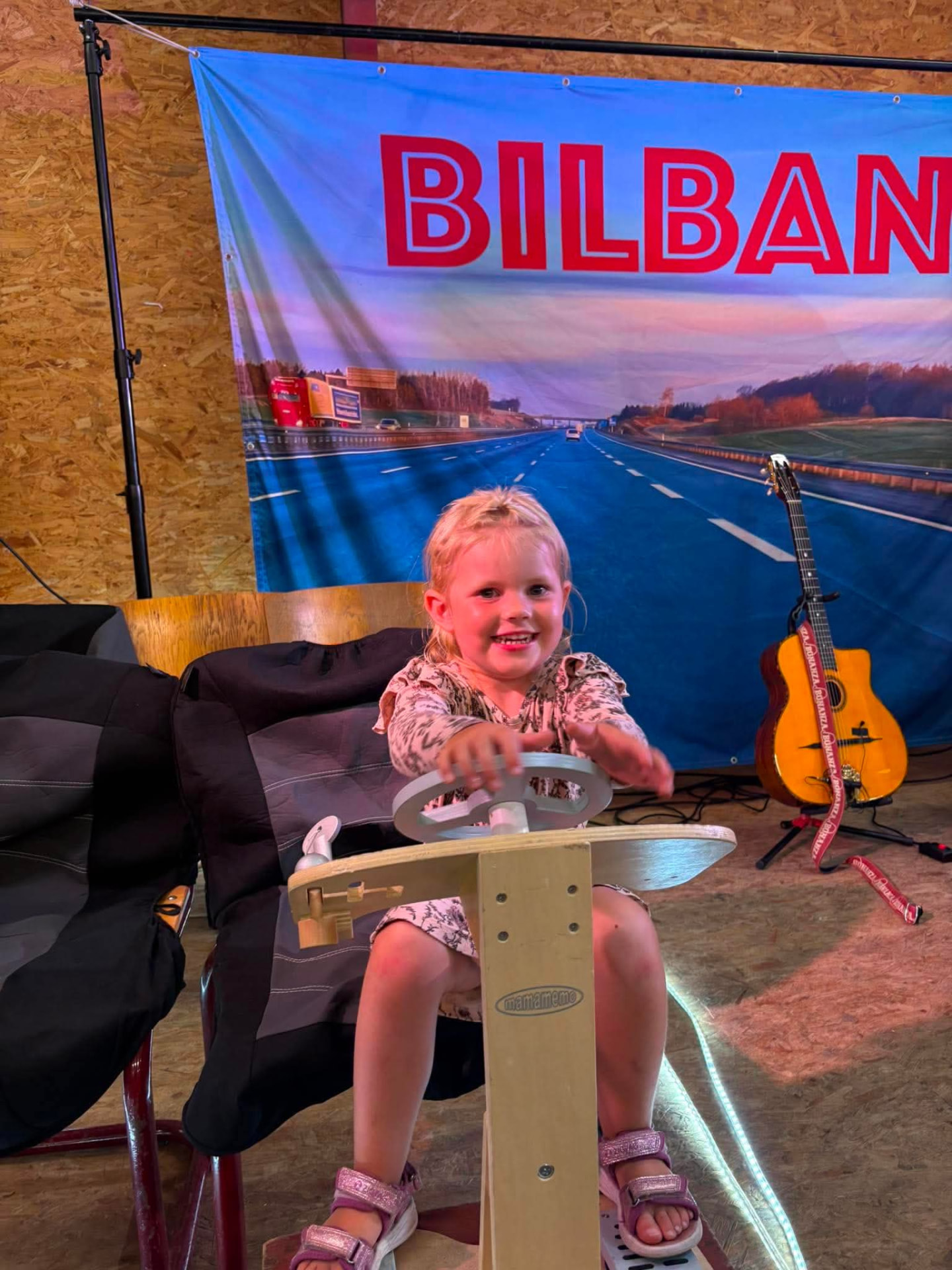 Pige kører på bilbanen i aktivitetshallen